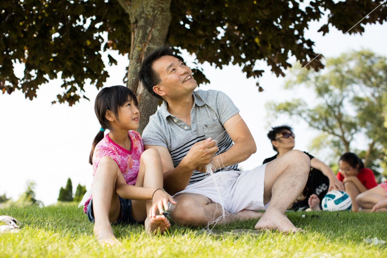 父亲和女儿在公园里放风筝。