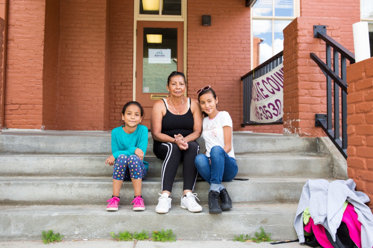 Amaria Aide White和她9岁的孙女Meylany和12岁的Heycel坐在科罗拉多州Leadville她们公寓大楼的台阶上。