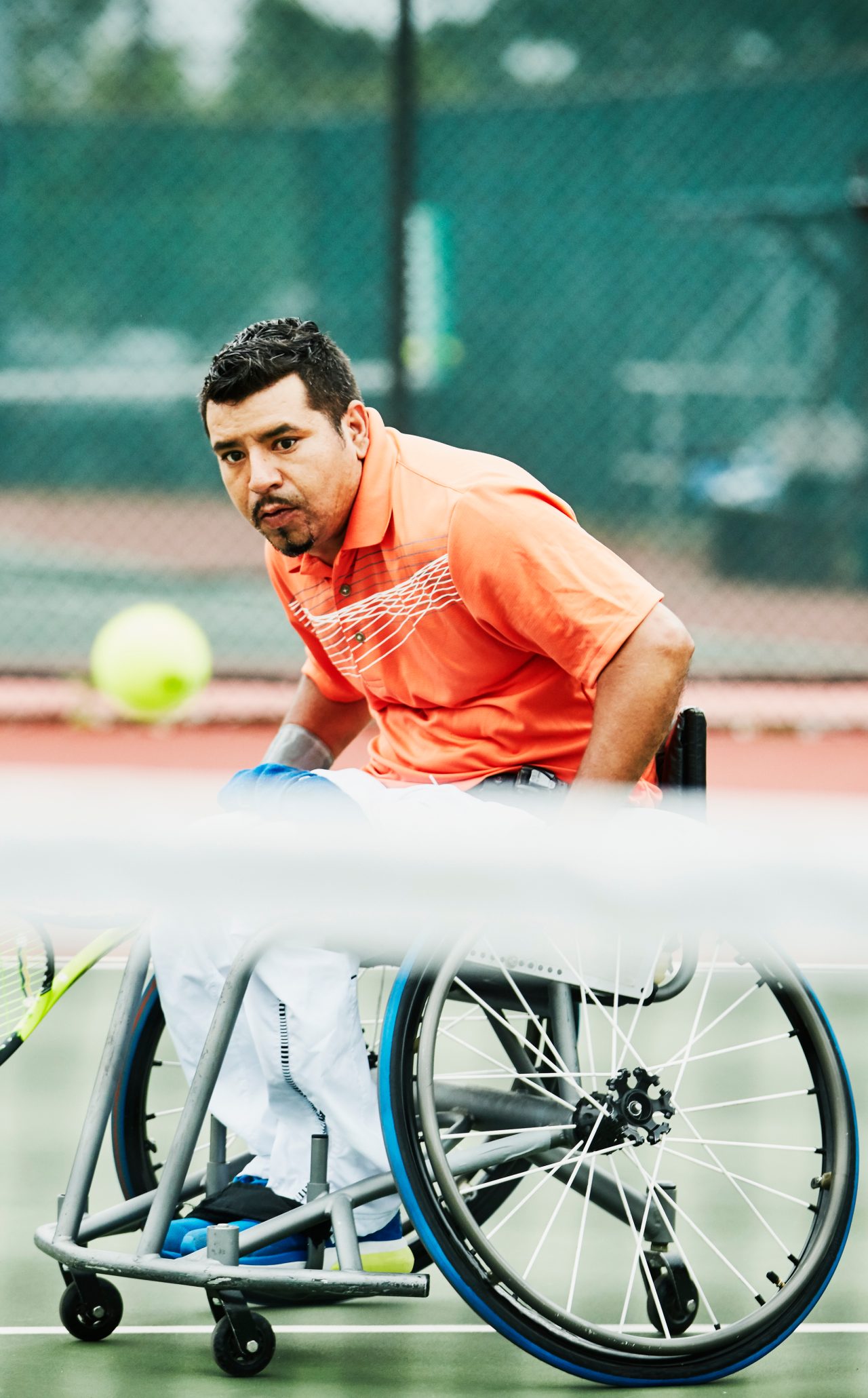 自适应运动员追逐down shot during wheelchair tennis match