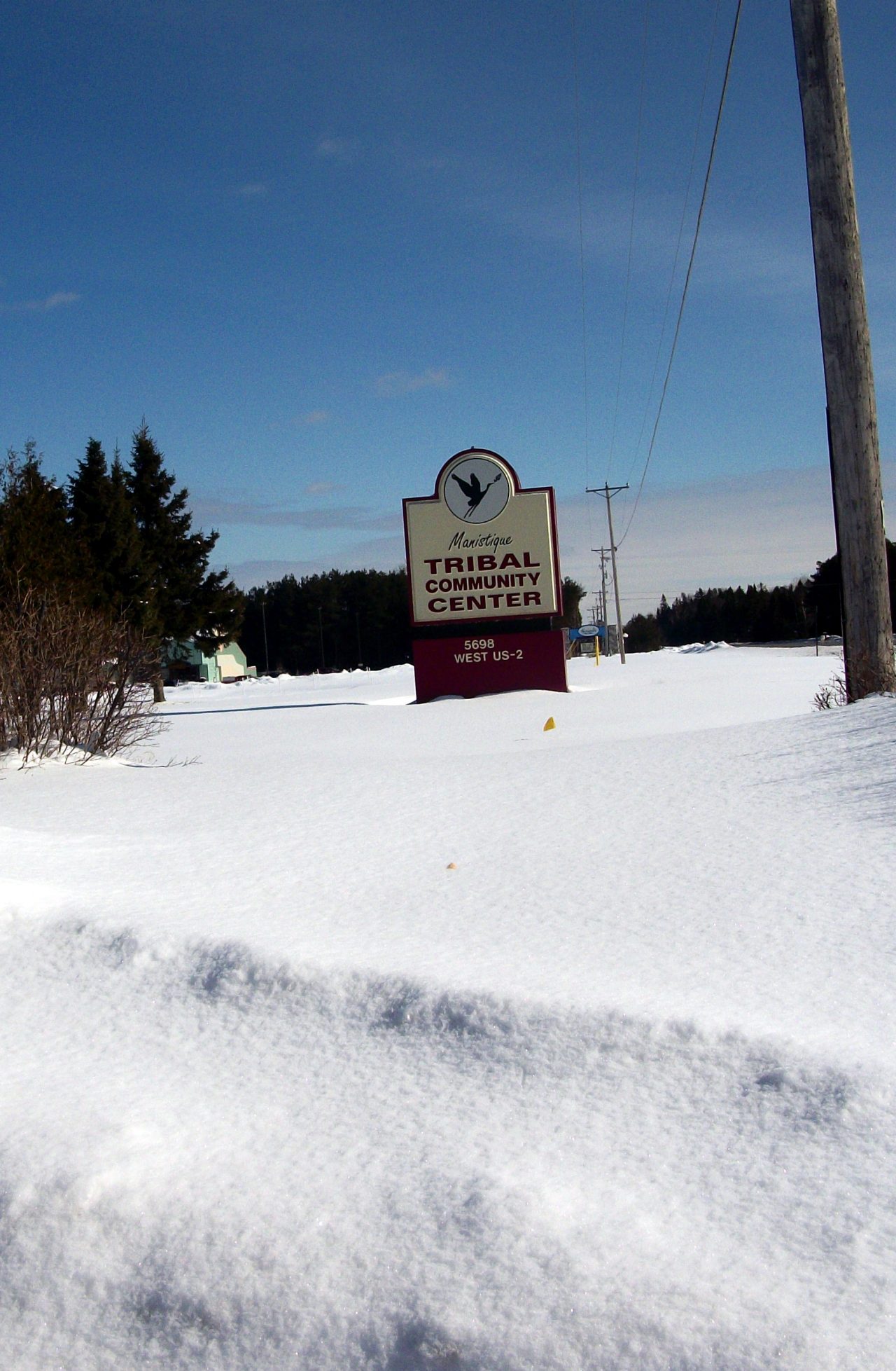 积雪覆盖的道路上的城镇标志。