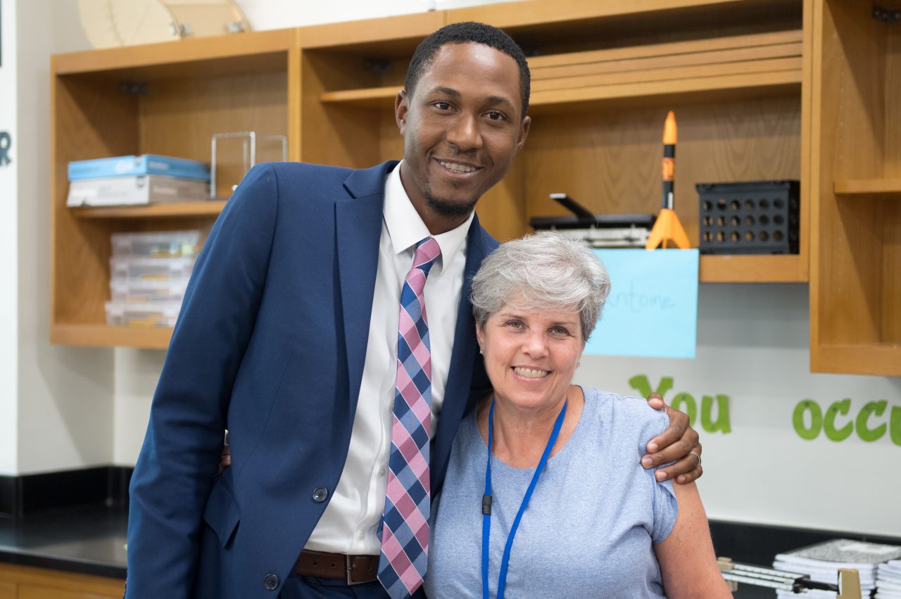 校长爱德华·j·安德森拥抱他四年级的老师苏珊·麦考伊，她对他的学生发展有很大的影响。她现在是坦格伍德中学的一名科学教师，该校正在参与OnTrack Greenville项目，以识别危险行为并更好地吸引学生。