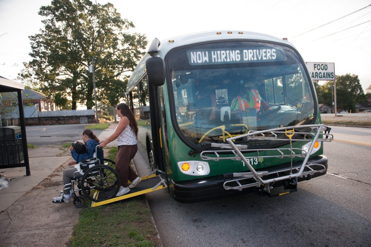 周三早上，格林维尔县居民朗达·赫林顿被她的女儿霍利·赫林顿推下巴士，乘坐绿联公交。格林维尔交通管理局将利用联邦拨款扩大他们的服务，包括延长工作时间和增加巴士。