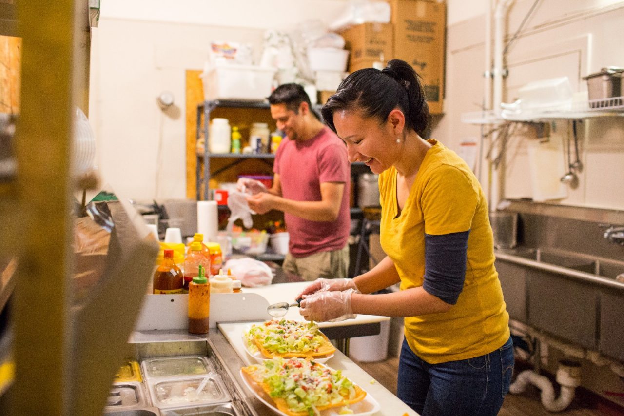企业主Nora Arreola和Saul Aguilar在科罗拉多州莱德维尔的El Mercadito墨西哥商店准备食物。